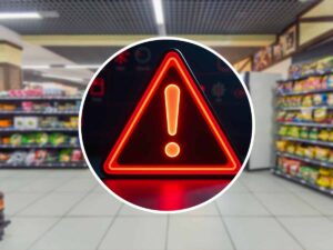 triangolo rosso di pericolo con dietro un supermercato